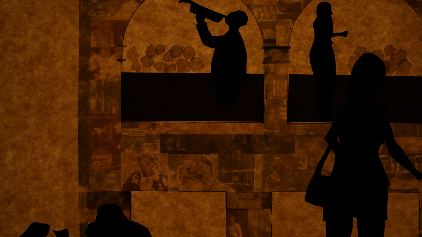 The black silhouettes of three people are visible against a yellowish-brown background. The background features the outline of a building’s façade, complete with two arches. The leftmost silhouette appears to be drinking from a long pitcher with a long spout; the person pictured appears to be standing still; the right-most silhouette appears to be a woman carrying a purse over her left shoulder.