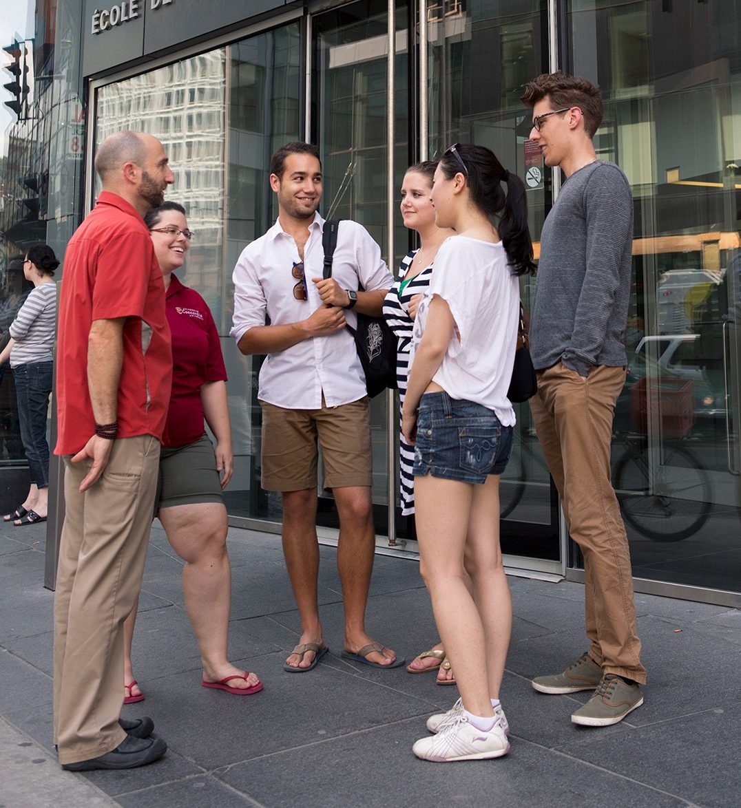 Une guide faisant visiter le campus parle avec un groupe d’étudiantes et étudiants potentiels, à l’extérieur du pavillon John-Molson.