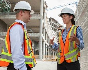 Two people wearing safety gear on a construction site