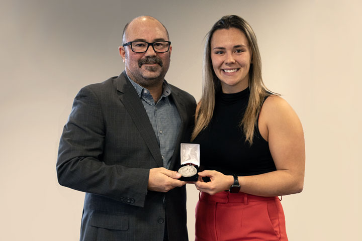 Athletic Director D’Arcy Ryan presenting Emmy Fecteau with the Weider Medal