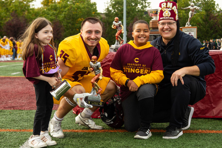 Emma and Arthur present the defensive MVP trophy to Concordia's Isaac Fulham.