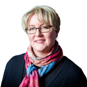Portrait of a smiling woman with short hair and glasses wearing a colourful scarf