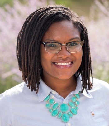 Headshot of smiling woman wearing light-blue button-up shirt and turquoise necklace