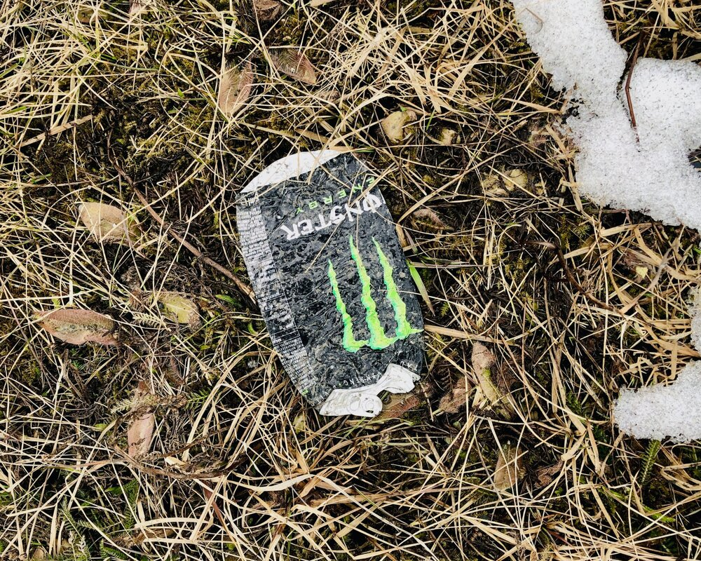 Picture of a degraded monster energy can on snowy ground