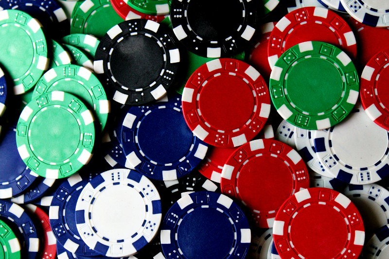 Green, blue, red and white poker chips in a pile