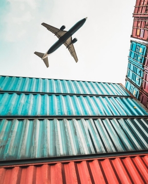 Image of a large airplane flyin gover shipping crates