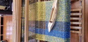 Picture of loom with blue, green, and yellow weaving
