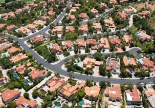 Picture of a developed, sprawled urban neighbourhood with large houses, trees, and roads