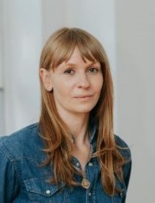 Photo of a woman with long strawberry blond hair and a blue shirt against a white background