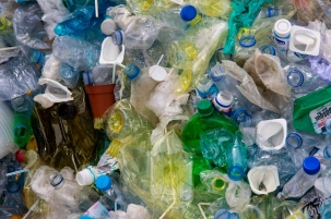 A pile of colourful single-use plastic cups, bottles, bags, and straws