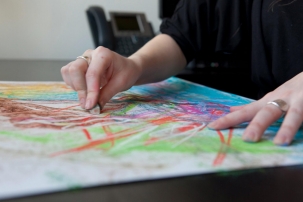 AN image of a hand drawing in coloyrful crayons on a piece of paper