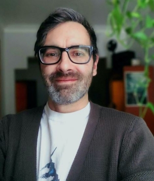 Photo of the speaker, Nicolas Renaud, a dark-haired, bearded man with glasses.