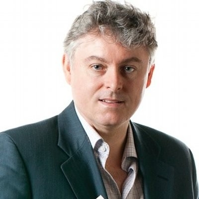 Headshot of man wearing charcoal blazer and light dress shirt.