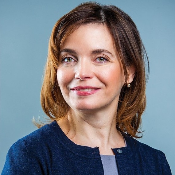 headshot of woman with brown hair wearing blue cardigan and lighter-blue shirt.