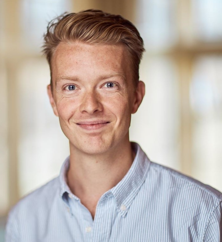 Headshot of man with light-coloured hair and blue collared shirt