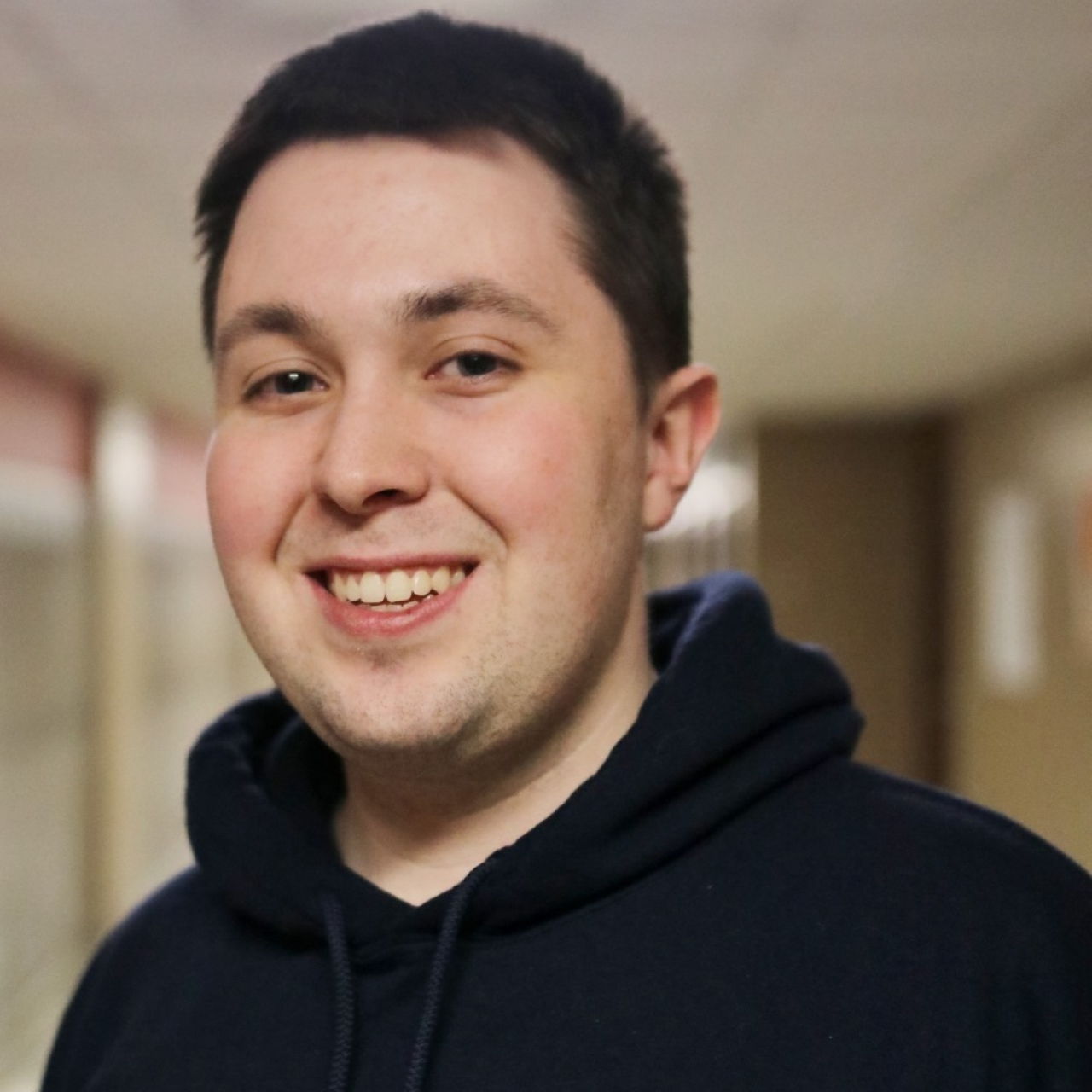 Smiling young man hearing black sweatshirt