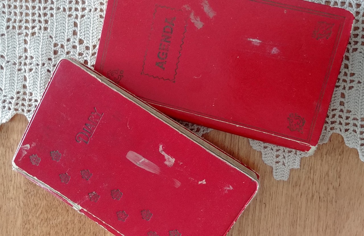 Image showing two red books on top of a lace table cloth on a wooden table