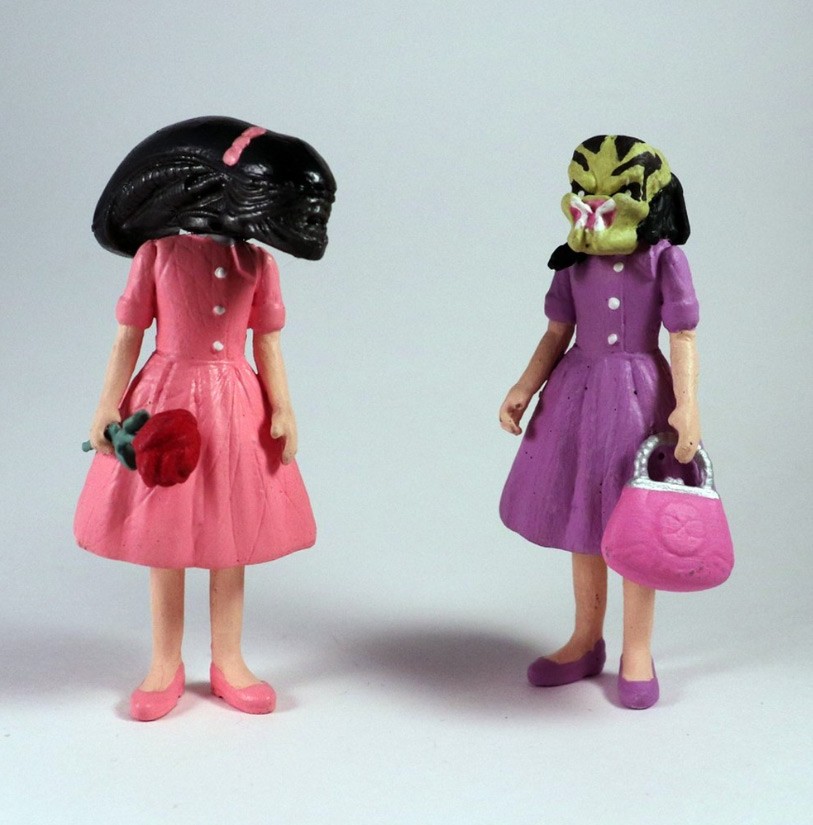 Two female action figures wearing dresses with alien heads