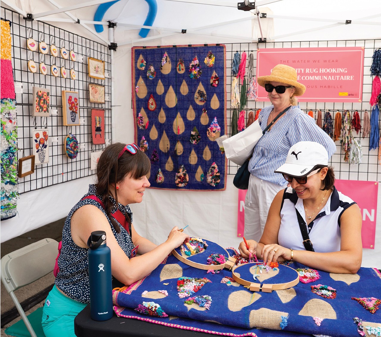 Artist presenting artwork to two visitors.