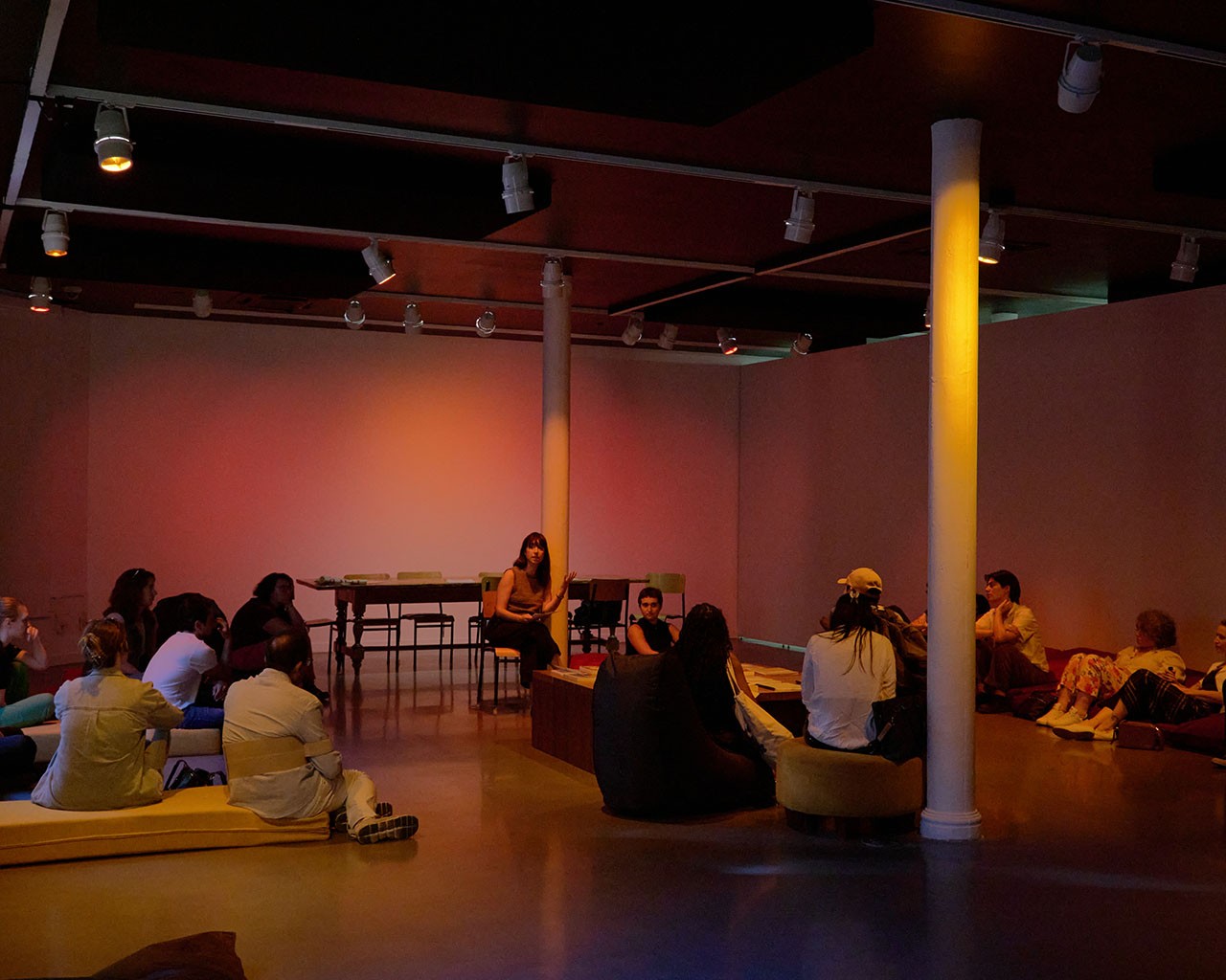 A group of people siting in a room and engaging in conversation