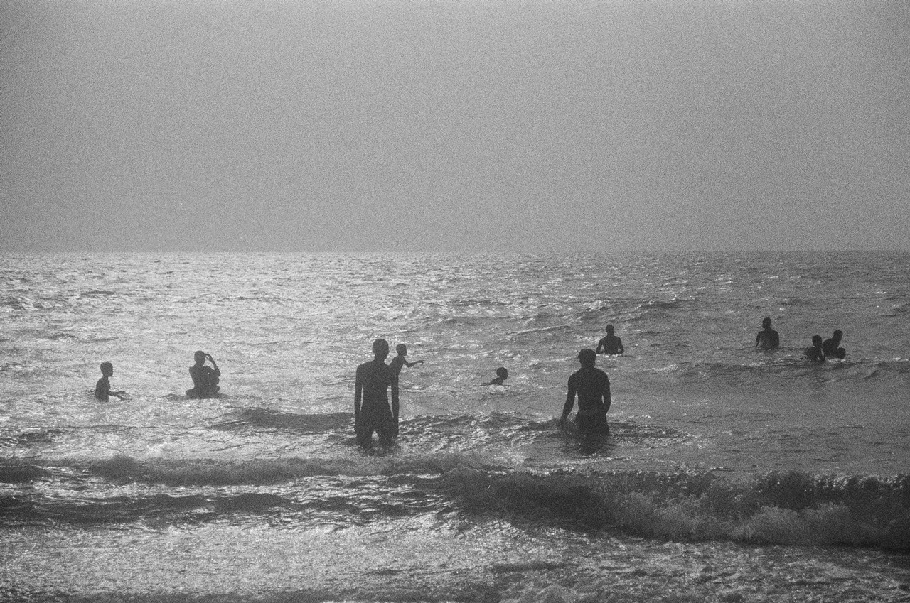 its a black and white image of a beach, the grain suggests that it's an analog camera
