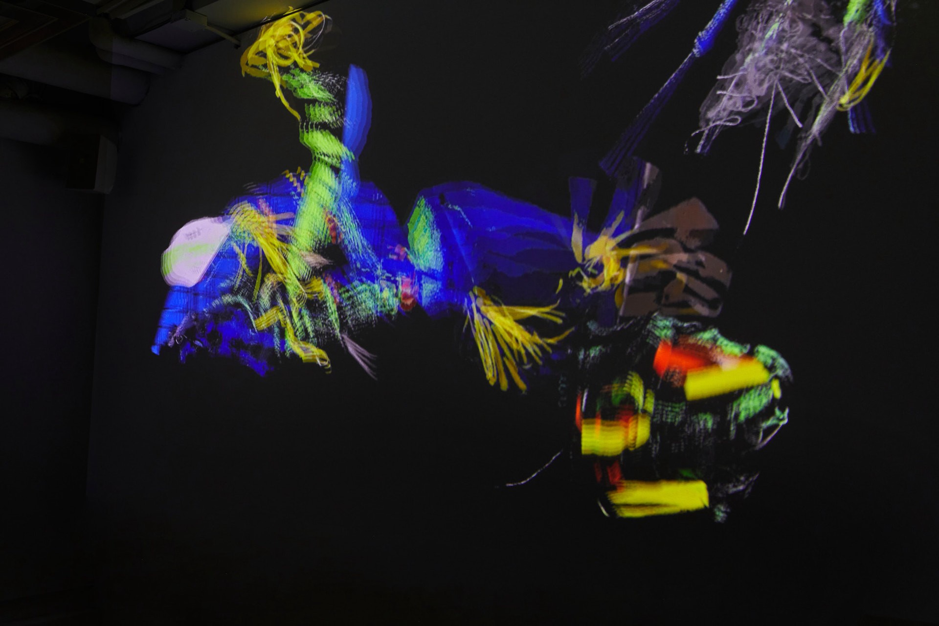 Projections onto a ceiling and walls of colourful amorphous limbs