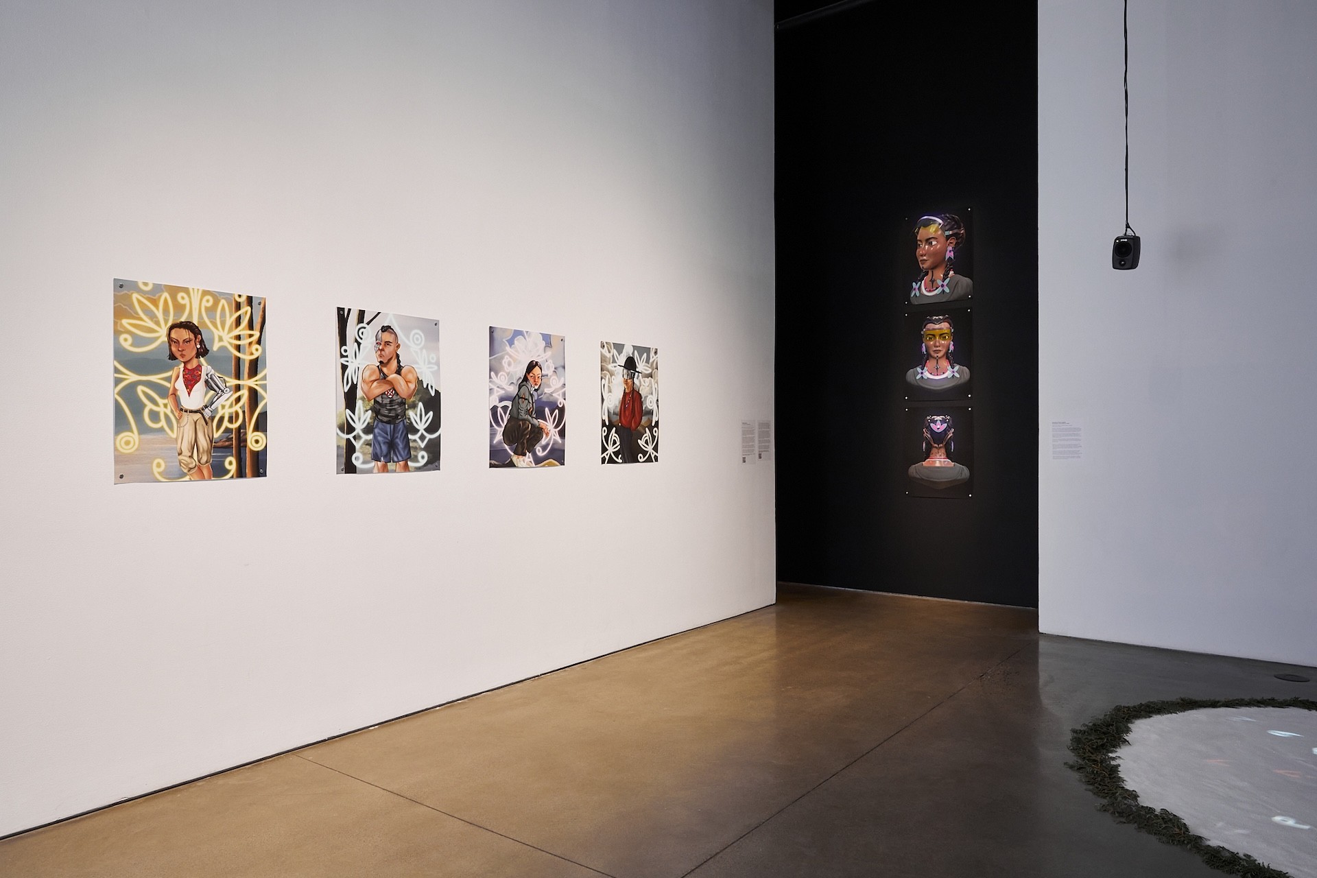 A gallery exhibition showing several printed digital paintings. One a black wall, three prints are stacked vertically, showing three angles of a digitally modelled character.  Along a white wall to the left of it are four digitally painted portraits of four "rezborgs" that are indigenous folks with both biological and technological parts.