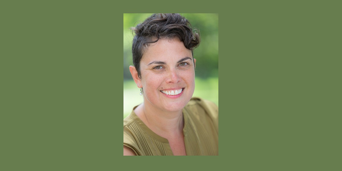 Portrait on smiling woman with short dark hair wearing beige shirt