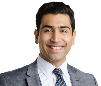 Headshot of smiling man wearing grey blazer, white shirt and striped tie