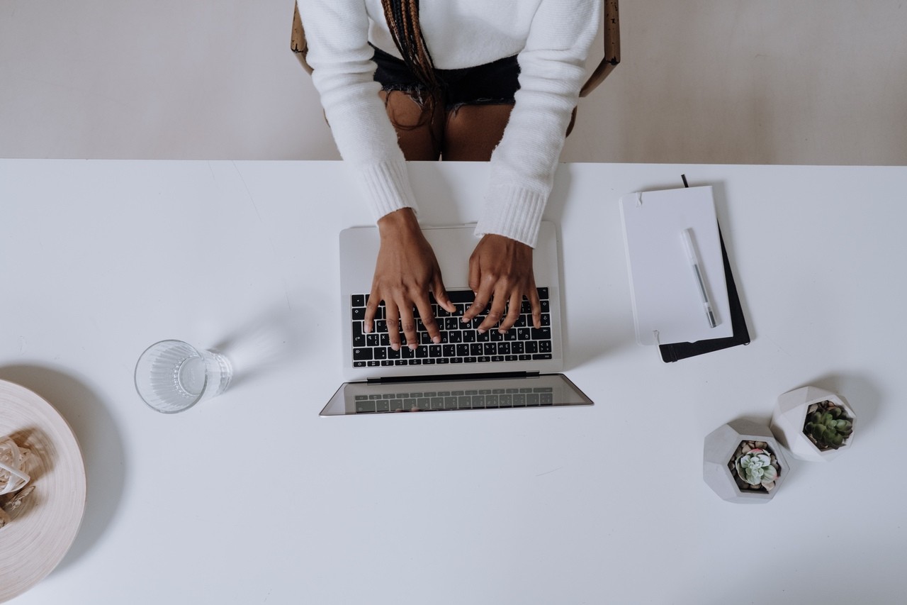 Overhead view of Black woman typing on laptop