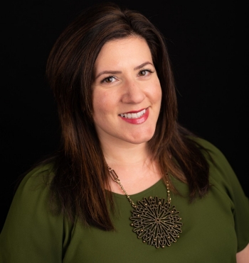 Smiling woman with brown hair wearing olive-green shirt