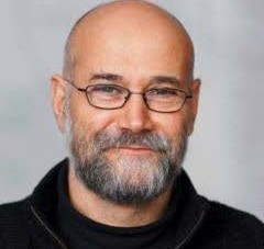 Portrait of man with glasses and beard smiling with mouth closed