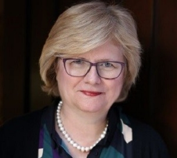 Portrait of blonde woman with blonde hair with glasses wearing pearl necklace
