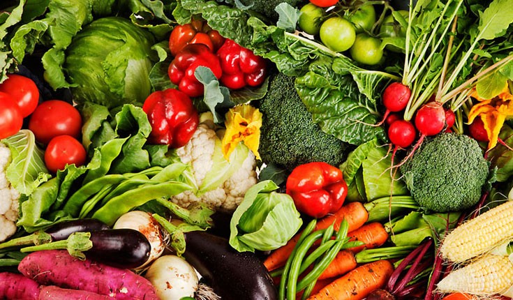 An overhead image of green, red, orange and yellow vegetables