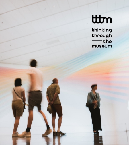 Four blurry people standing in an exhibition