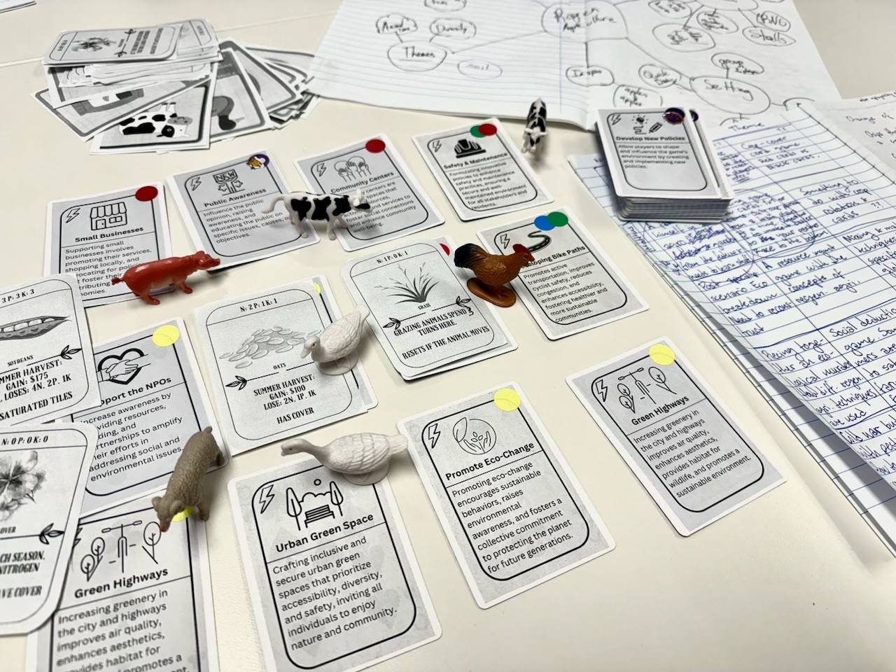 Game tokens and game cards with instructions on a white table.