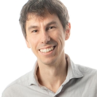 A man with brown hair wears a collared shirt.