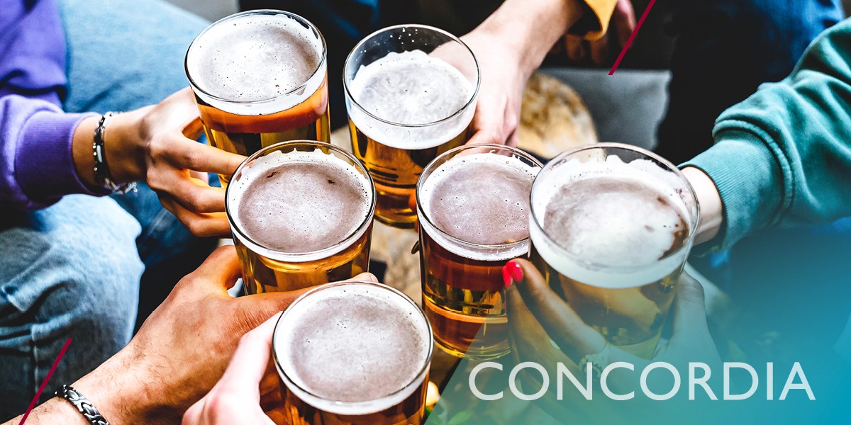 A photo of several hands clinking beer pints together for a toast.