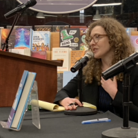 Woman discussing her book at a microphone