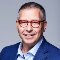 man wearing brown-rimmed glasses and a blue suit with button-up shirt
