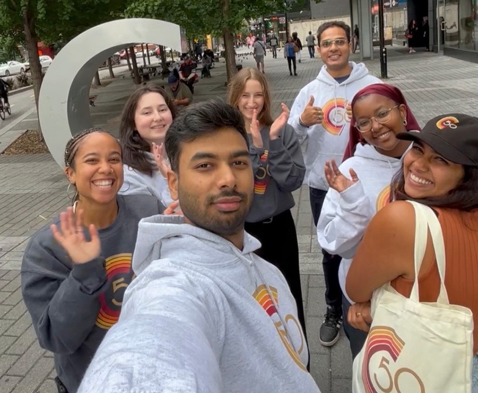 Seven Concordia students wear hoodies and T-shirts with the university's 50th aniversary logo emblazoned upon them