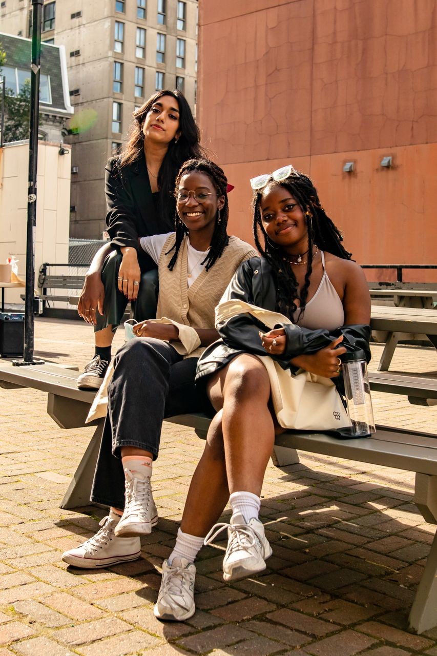 Three women sitting at picnic tables