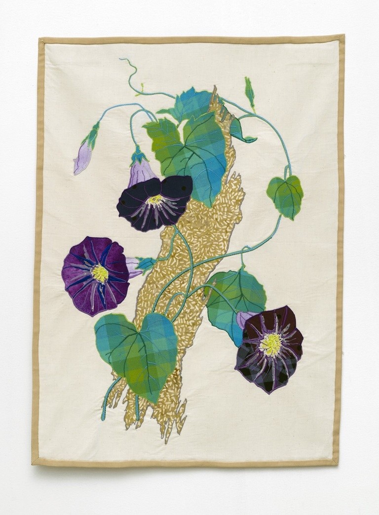 An embroidery with two dark purple flowers