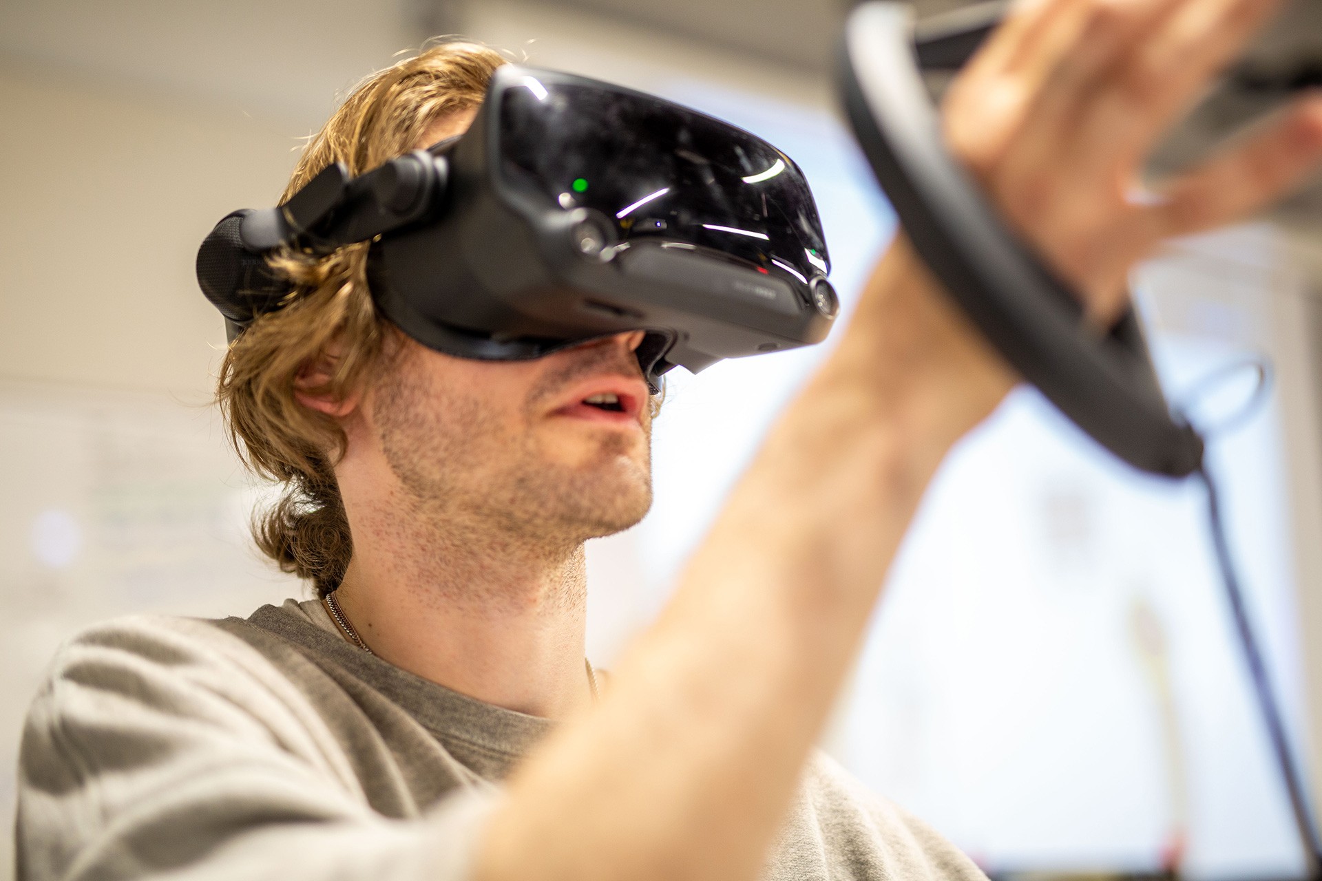 A student wearing a VR headset immersed in a VR (virtual reality) experience