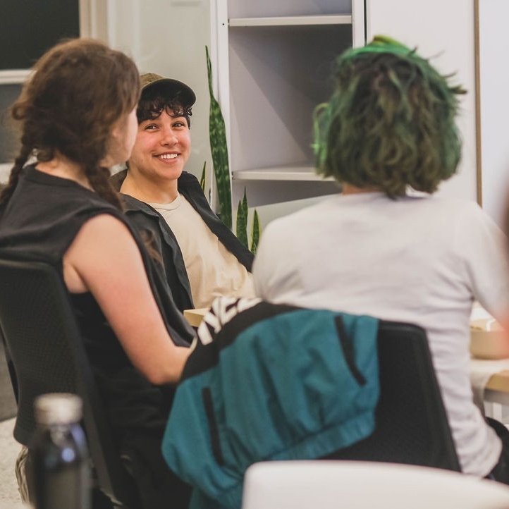 3 people sitting, one facing the camera