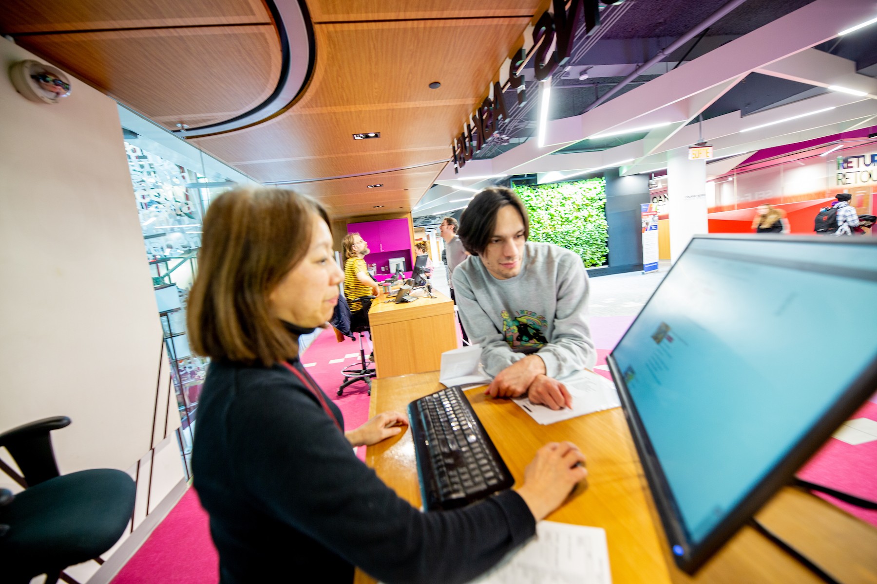 A student speaks with a librarian at the Webster Library at Concordia