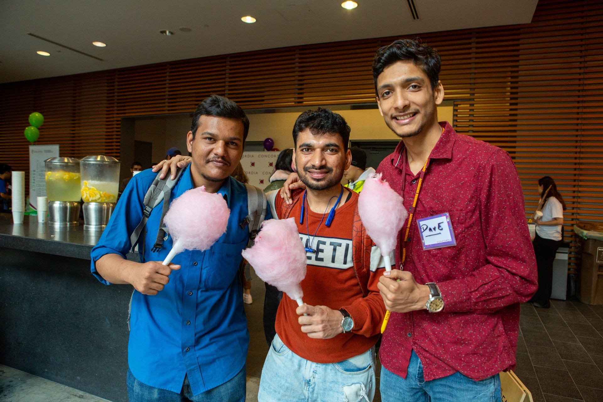 A group of friends at Orientation holding cotton candy and smiling