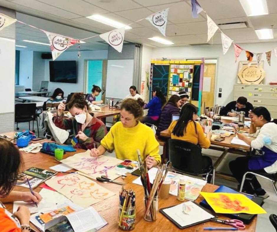 A group of students having conversations while enjoying some snacks and halloween decorations.