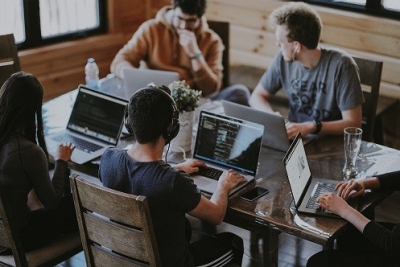 People sitting around a table with laptops