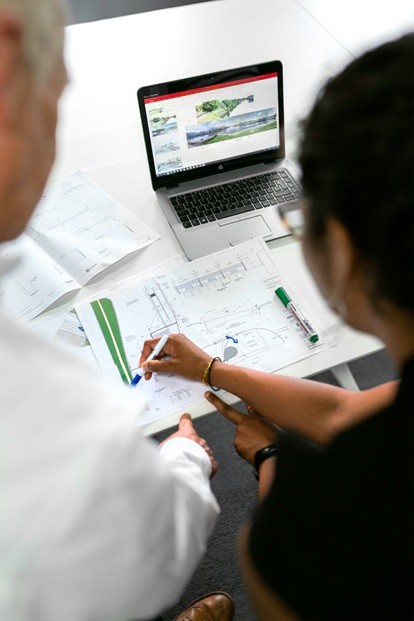 Two engineers sitting in front of a laptop